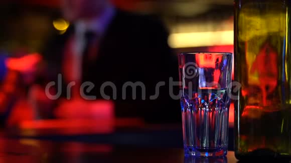 酒吧柜台上的空酒精瓶背景上的情侣喝酒聚会放松视频的预览图