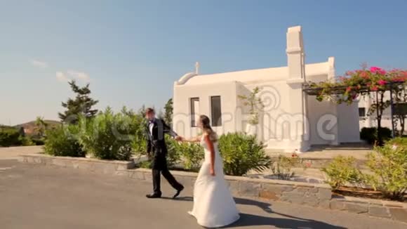 婚礼当天新郎新娘在酒店背景下散步视频的预览图