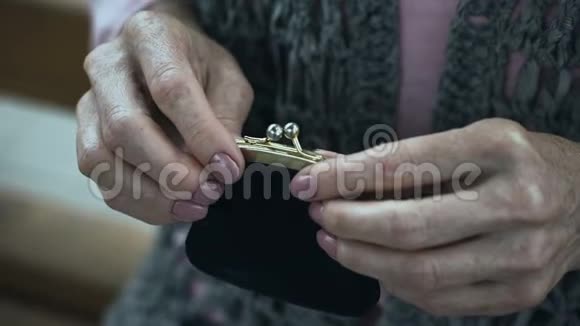 祖母颤抖着把硬币放进钱包里退休老人贫穷特写镜头视频的预览图
