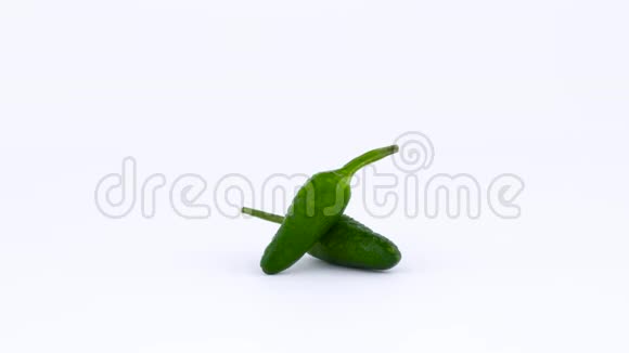 两个带有水滴的绿色小辣椒在转盘上旋转孤立于白色背景视频的预览图