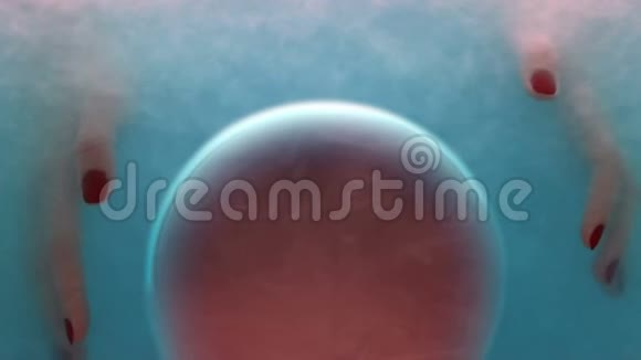 双手放在红色球体周围的泡沫中生命起源细胞特写视频的预览图