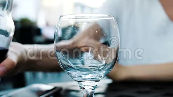 女人用杯子从餐厅的瓶子里倒汽水柠檬水特写镜头慢动作视频的预览图