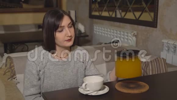 咖啡屋里的布鲁内特女人倒了维生素茶视频的预览图