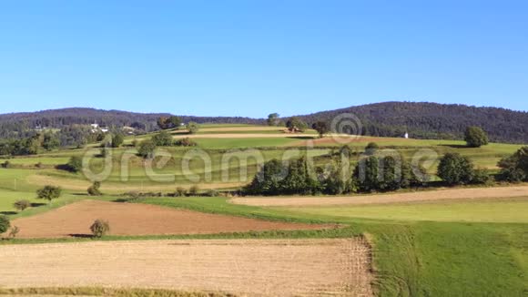 在欧洲山区田野和混有森林的牧场上空飞越农田视频的预览图