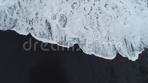 波在葡萄牙马德里亚岛海岸的一个黑色沙滩上破裂视频的预览图