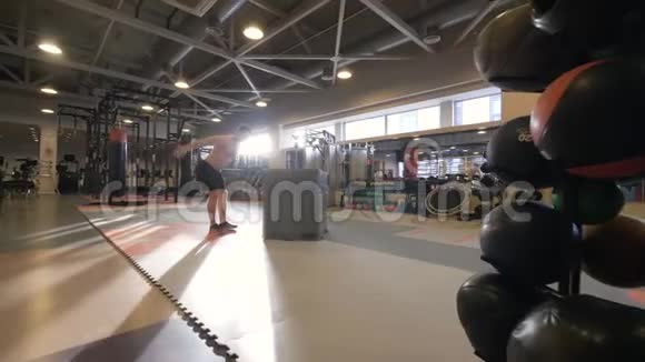 运动员在健身俱乐部慢动作交叉训练平台上跳跃视频的预览图