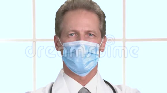 合上戴面具的成熟医生看着相机微笑着视频的预览图