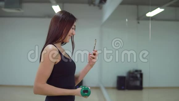穿着运动服在健身房自拍的年轻美女视频的预览图