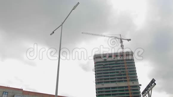 起重机在一栋高层建筑的背景下在施工现场工作视频的预览图