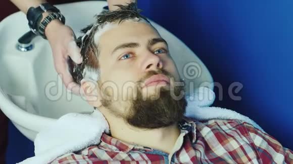 年轻的时髦男人在理发店洗头发视频的预览图