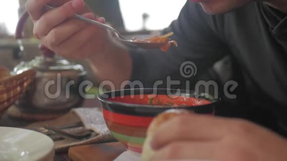 一双面目全非的手在餐馆里吃汤一个男人吃健康的饭午餐健康的生活方式视频的预览图