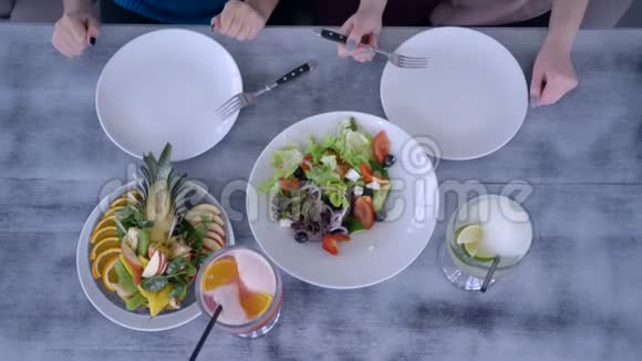 美丽的食物俯视图人们在用餐时在餐桌上供应新鲜沙拉和水果饮料视频的预览图