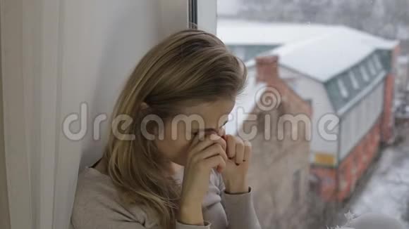 金发女人坐在窗台上揉眼睛视频的预览图