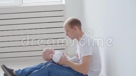 家庭和儿童的概念年轻的父亲抱着他刚出生的女儿视频的预览图