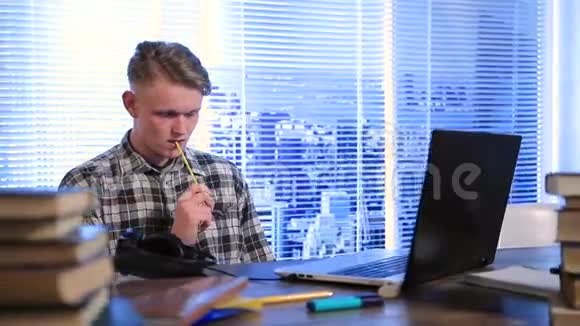英俊的学生用铅笔在嘴里思考视频的预览图