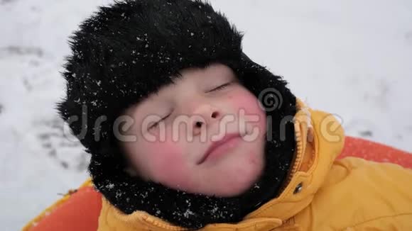 冬天的雪乐趣一个男孩的肖像下雪了视频的预览图