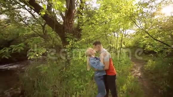 年轻夫妇站在森林河附近拥抱视频的预览图