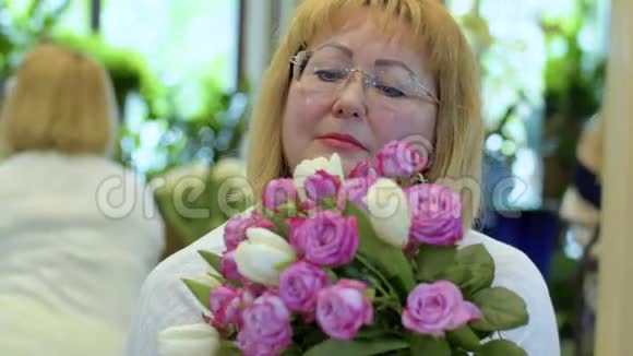 迷人的成熟女人带着玫瑰和郁金香视频的预览图