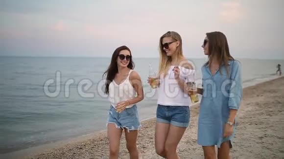 一群女性朋友在日落时分在海边的海滩上慢动作享受饮料青年妇女视频的预览图