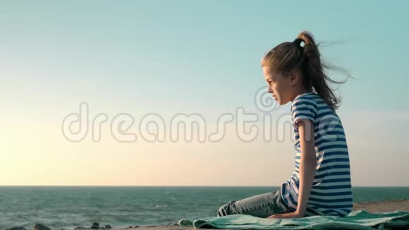 暴风雨特写镜头时坐在海滩码头上的悲伤小女孩视频的预览图