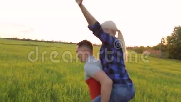 一个背着女孩的男人在田野上奔跑视频的预览图