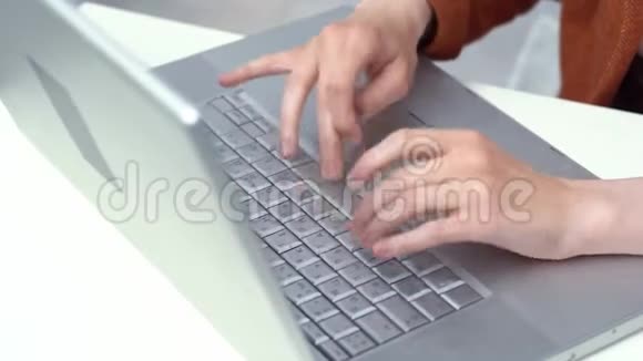 时髦的黑发女人在家里用笔记本电脑工作视频的预览图