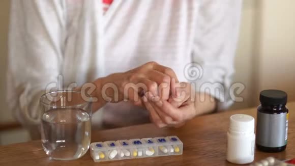 关节炎患者的特写手臂成熟的女人用水吃药丸和维生素医学和医学视频的预览图