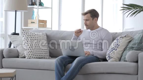 咳嗽男人在沙发上工作时咳嗽视频的预览图
