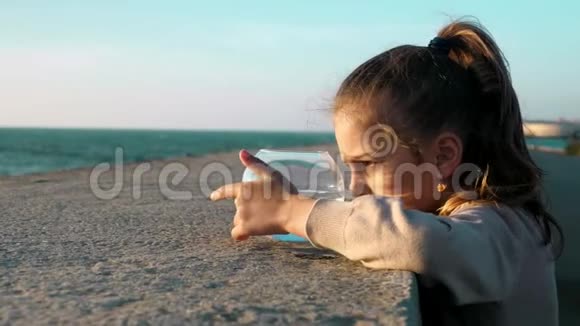 玩可爱的小女孩看着鱼缸里的鱼和她在海滨玩寿命概念视频的预览图
