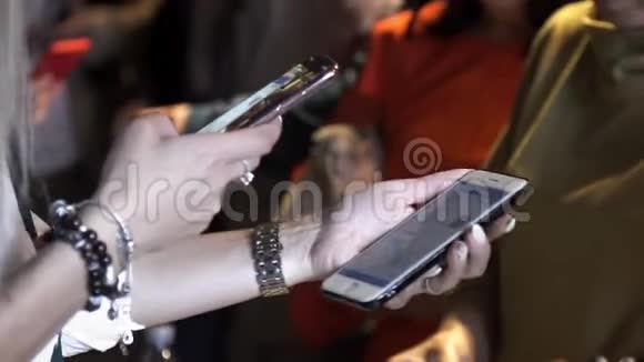 在一个聚会上用手镯在另一部智能手机上拍摄一些信息为女性的手合上场景视频的预览图