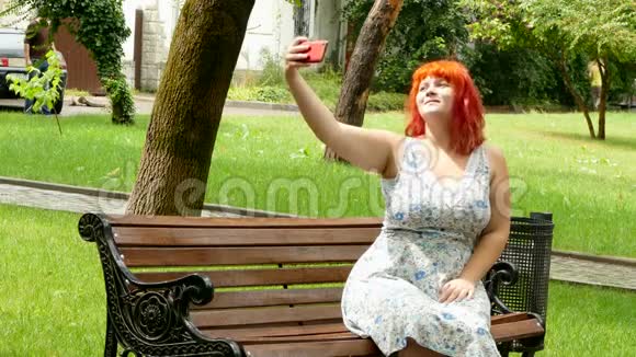 红发女孩在公园长椅上自拍视频的预览图