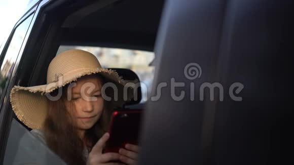 带着草帽的女孩用智能手机分享社交媒体公路旅行概念视频的预览图