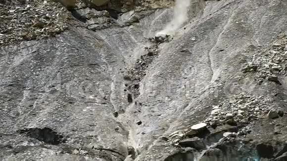 山脉中缓慢运动的落岩接近从融化的冰川上掉下来的石块视频的预览图