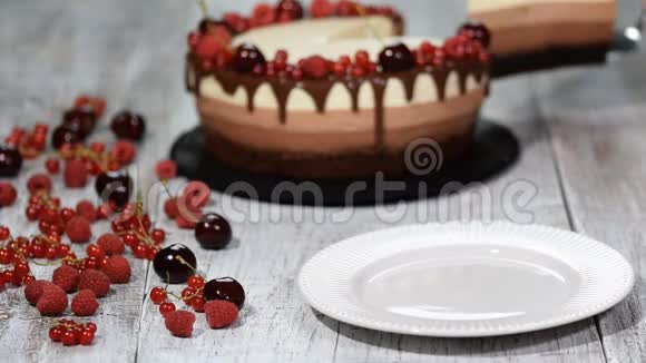 一块美味的三块巧克力慕斯蛋糕上面装饰着新鲜的浆果视频的预览图