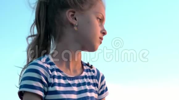 可爱的梦幻小女孩穿着条纹衬衫天空背景日落时头发不断变化视频的预览图