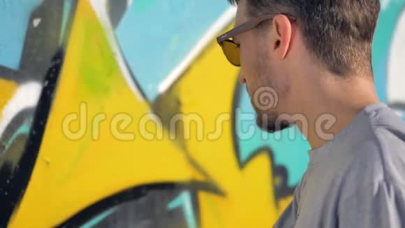 涂鸦艺术家正在墙上黄色字母附近画一条黑线视频的预览图