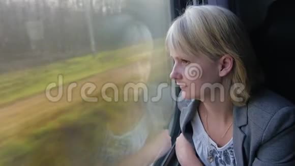 一个穿西装的女人坐火车看着窗外视频的预览图