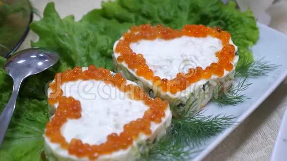 三明治带有心形的红色鱼子酱盘子和沙拉片上有鳃节日餐桌视频的预览图
