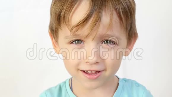 特写一个孩子看着镜头笑着放慢脚步露出牙齿孩子表现出快乐和巨大视频的预览图