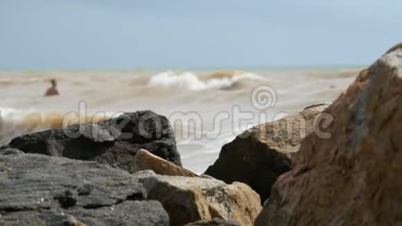 海滩上的巨石肮脏海浪的背景视频的预览图