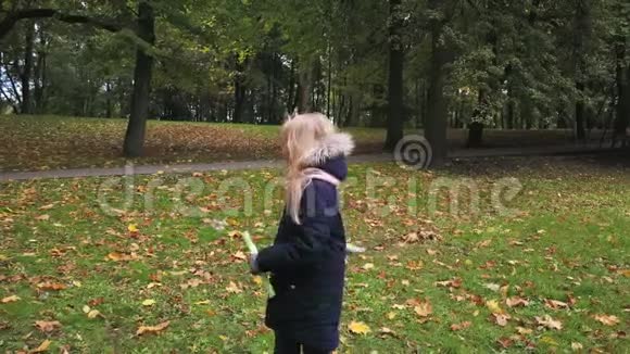 一个女学生在秋天的公园里玩肥皂泡视频的预览图