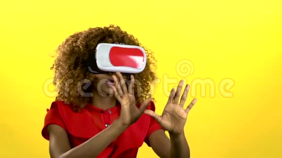 在虚拟现实眼镜中的穆拉托正在观看一段有趣的视频黄色背景慢动作视频的预览图