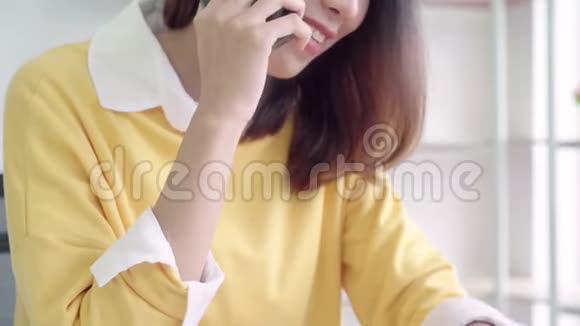 漂亮的聪明商务亚洲女人穿着智能休闲服在笔记本电脑上工作坐在桌子上打电话视频的预览图