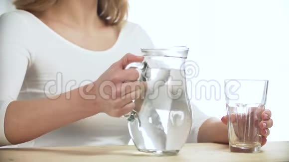 女人把水从巨耳特写镜头倒入玻璃视频的预览图