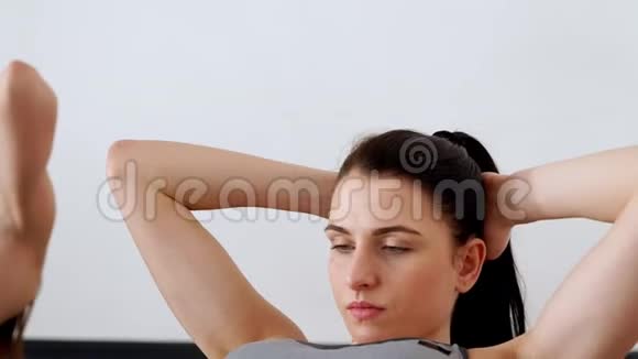 两个女人特写仰卧着做腿抬高的仰卧起坐普拉提运动在工作室白色视频的预览图