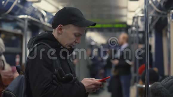 帅哥看屏幕智能手机在地铁列车上使用移动应用程序视频的预览图