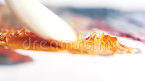 白色大刷子涂抹橙色油漆通过平滑的活动在油漆帆布上行动艺术和绘画视频的预览图