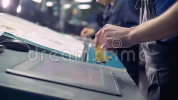 男工人在工厂生产线旁使用数字计算机触摸屏视频的预览图