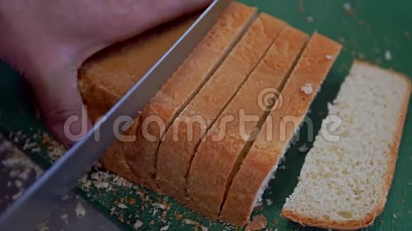 一个女人用面包刀切一条面包视频的预览图