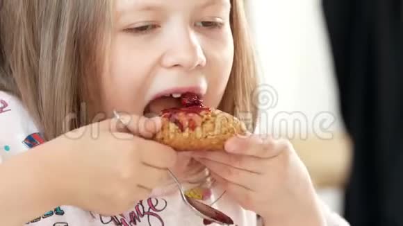小女孩吃自制的饼干用自己的手准备果酱视频的预览图